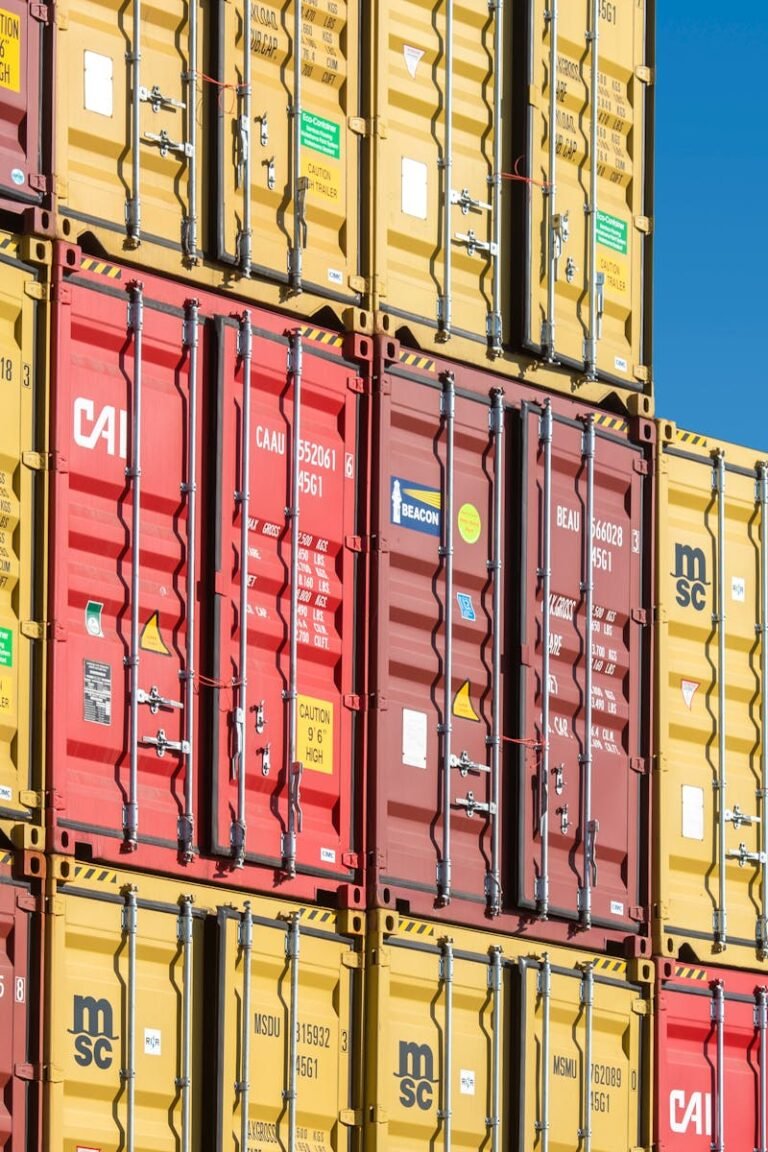 Colorful shipping containers stacked against a clear blue sky, representing global trade and transportation.
